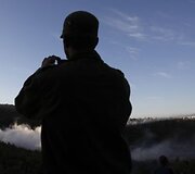 Izraelio karys fotografuoja gaisrą gesinantį lėktuvą netoli Haifos miesto.
