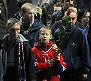 Žmonės eile eina pro žuvusiųjų karstus.