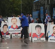 Komandos gerbėjai su žuvusiųjų portretais