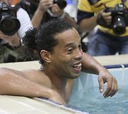 Brazilų puolėjas Ronaldinho mėgaujasi baseinu ir fotografų dėmesiu.