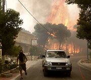 Gaisrui pasiekus Atėnus ugniagesiai kovoja su liepsnomis, o žmonės evakuojami i&scaron; priemiesčių.
