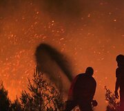 Gaisrui pasiekus Atėnus ugniagesiai kovoja su liepsnomis, o žmonės evakuojami i&scaron; priemiesčių.