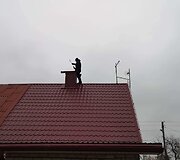 Kaminkrėtys Tadas ant namo stogo