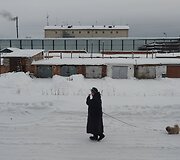 Per virtuvės langą matomas kalėjimo vaizdas ir moteris su &scaron;uneliu