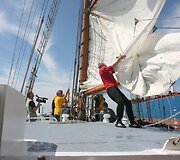 Krep&scaron;ininkai drauge i&scaron;kėlė burlaivio bures.