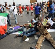 Nigerijoje protestuotojai guli ant kelio.