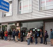 Žmonės laukia prie įdarbinimo biurio Madrido rajone.