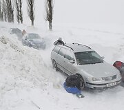 Vyrai deda ant automobilių padangų grandines.