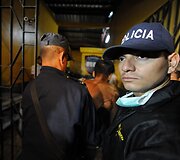 Policininkai lydi sužeista kalinį.