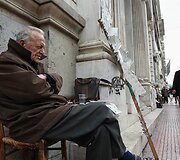 Vyras gatvėje pardavinėja loterijos bilietus