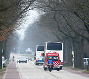 Autobusai policijos lydimi į Melsbruko karinį oro uostą.