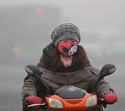 Kinijoje &scaron;iltai apsirengusi mergina važiuoja motoroleriu.