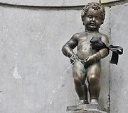 Briuselio sisiojantis berniukas su juodu kaspinu ant rankos
