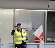 Filmuoja streikuojantis oro uosto darbuotojas.