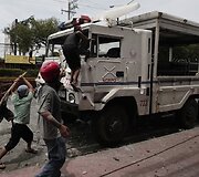 Protestuotojai daužo policijos sunkvežimį.
