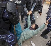 Nepalo policininkai ne&scaron;a moterį.