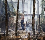 Vyras eina per sudegusį Rohingijos kaimą