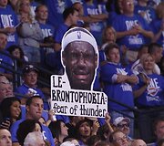 Oklahomos &bdquo;Thunder&ldquo; gerbėjos laiko i&scaron;kirptą LeBrono Jameso portretą.