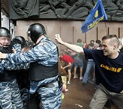 Protestuotojas pur&scaron;kia a&scaron;arines dujas į policininkus.