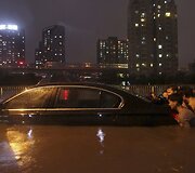 Vietos gyventojai stumia apsemtą automobilį