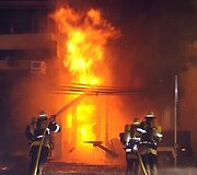 Susprogdinus bombą gaisrininkai skubėjo gesinti &scaron;alia užsiliepsnojusių pastatų.