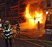 Susprogdinus bombą gaisrininkai skubėjo gesinti &scaron;alia užsiliepsnojusių pastatų.