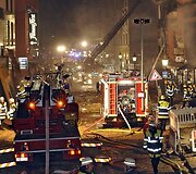 Susprogdinus bombą gaisrininkai skubėjo gesinti &scaron;alia užsiliepsnojusių pastatų.