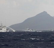 Taivano pakrančių sargybos laivas pur&scaron;kia vandenį link Japonijos pakrančių sargybos laivų.