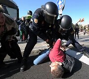 Policininkai sulaikė protestuotoją.