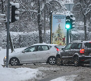 Automobiliai apsnigtoje gatvėje