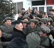 Kim Jong-Unas su &scaron;alies mokslininkais džiaugiasi sėkmingu raketos paleidimu.
