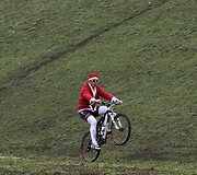 Kalėdų senelio kostiumu apsirengęs dviratininkas