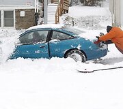 Stumiamas sniege užklimpęs automobilis