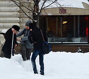 Jaunimas padeda senoliui bristi per sniegą