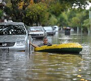 Vyras gatvėje plaukia su pripučiama valtimi.
