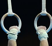 Į žiedus įsikibęs gimnastas