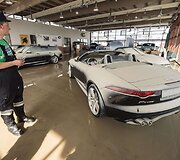 Gaisrininkas stovi potvynio i&scaron;plautame automobilių salone