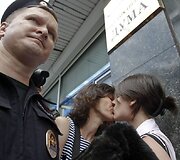 Policininkas prie besibučiuojančių merginų