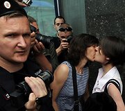Policininkas prie besibučiuojančių merginų