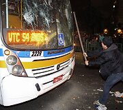 Protestuotojas daužo miesto autobusą.