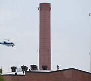 Policijos sraigtasparnis ir policijos pareigūnai ant stogo.