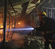 Gaisrininkai kovoja su ugnimi fabrike.