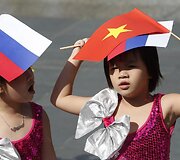 Mergaitės su Rusijos ir Vietnamo vėliavomis