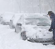 Vyras valo sniegą nuo automobilio