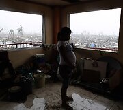 Filipinuose taifūno Haiyan nuniokotame name maistą ruo&scaron;ia besilaukianti moteris
