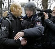 Policininko sulaikomas protestuotojas su kauke.