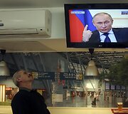 Kijeve vyras žiūri Rusijos prezidento Vladimiro Putino spaudos konferenciją.