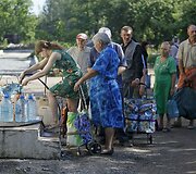 Slovjanske žmonės laukia eilėje prie vandens