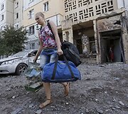 Mergina su savo daiktais i&scaron;eina i&scaron; Donecke ap&scaron;audyto daugiabučio