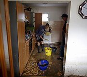 Bosnijoje ir Hercegovinoje moteris valo namus atslūgus potvyniui